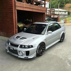 a silver car parked in front of a garage