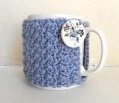 a crocheted coffee cup with a button on it