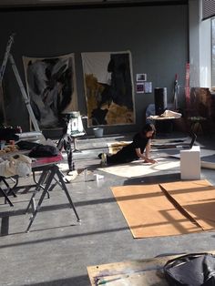 a person laying on the ground in an art studio