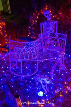 a skeleton sitting on top of a bench covered in blue lights