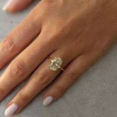 a woman's hand with a diamond ring on it