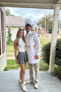 a man and woman dressed up in costumes on a porch with an american flag behind them