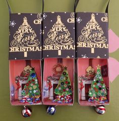 three christmas tree ornaments are in their boxes