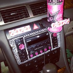 the radio in the car is decorated with pink and silver decorations on it's dash board