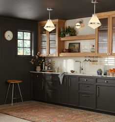 a kitchen with wooden cabinets and an area rug in front of the counter top that has a clock on it