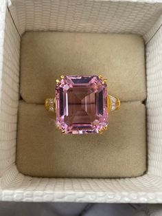 a pink tourmaline and diamond ring sitting in a box on top of a table