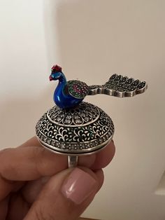 Elevate your style with our exquisite 925 silver peacock ring, handcrafted by skilled Indian artisans. This one-of-a-kind piece features a captivating rotating peacock design adorned with intricate stone and enamel work. Designed to stand out, this ring brings the beauty of the peacock to life, with every detail reflecting the artistry of India's heritage. Wear a symbol of grace and elegance while celebrating the essence of motion and creativity. Embrace the craftsmanship that makes this ring tr Unique Peacock Design Wedding Jewelry, Elegant Peacock Design Rings As Gift, Elegant Peacock Design Rings For Gifts, Elegant Peacock Design Jewelry Ring, Elegant Peacock Design Ring, Symbol Of Grace, Peacock Ring, Grace Symbol, Rotating Ring