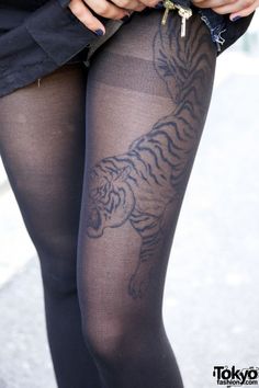 a woman in tights with a tiger tattoo on her leg