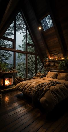 a large bed sitting under a window next to a fire place on top of a wooden floor