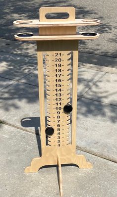 a tall wooden rack with many different types of numbers on it's sides and holes in the middle