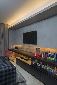 a bed room with a neatly made bed and a flat screen tv on the wall