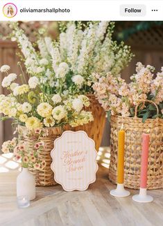 two baskets with flowers in them on a table next to candles and a sign that says happy mother's day