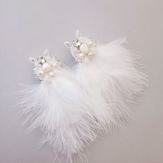 Elevate your bridal ensemble with these exquisite boho feather earrings, designed to add a touch of ethereal charm to your special day. Crafted with meticulous attention to detail, each earring features delicate white feathers adorned with shimmering crystals and lustrous pearls, creating a graceful and timeless aesthetic. Features: Elegant Design: These feather earrings exude an air of elegance and sophistication, perfect for the modern bride seeking a bohemian-inspired look. Versatile Closure Elegant Feather Dangle Jewelry, Elegant Silver Feather Earrings, White Feather Dangle Earrings, Bohemian Bridal Earrings For Wedding, Elegant Feather Dangle Earrings, Elegant Feather Earrings For Gift, Elegant Dangle Feather Earrings, Elegant Dangle Earrings With Feathers, White Dangle Jewelry For Bride