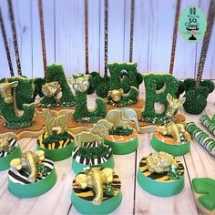 there are many green and gold decorations on the table with zebra print plates in front of them