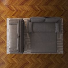 an overhead view of a living room with wood flooring and grey couches on the center table