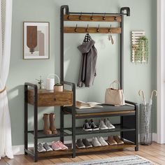 a coat rack with shoes and purses on it in front of a green wall