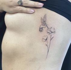 a woman's stomach with a humming tattoo on it