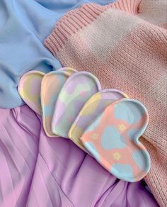 three heart shaped plates sitting on top of pink and blue sheets