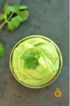 a small glass filled with green food and garnished with cilantro leaves