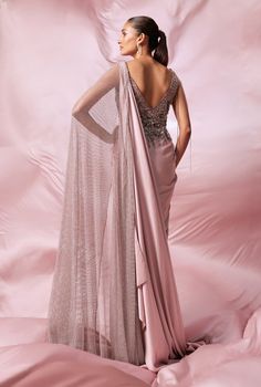 Elegance meets craftsmanship in our soft pink double palla saree gown. This exquisite piece showcases a sophisticated draping technique, beautifully hand-embroidered with sequins, katdana, and shimmering crystals. Evening Draped Gown With Zari Work, Anarkali Pre-draped Saree With Sequins For Evening, Pink Floor-length Evening Lehenga, Evening Floor-length Pink Lehenga, Pink Saree With Mirror Work, Elegant Draped Pink Lehenga, Evening Gown With Resham Embroidery In Traditional Drape, Embellished Saree Dress For Gala, Anarkali Embellished Evening Saree