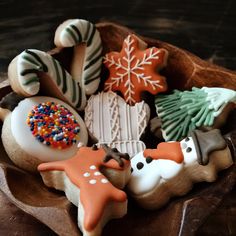 decorated cookies in a wooden bowl on a table