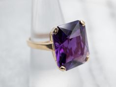 This exquisite yellow gold ring is set with a stunningly faceted Amethyst in a classic solitaire style. Expertly crafted, this cocktail ring is an eye-catching statement piece for any occasion.Metal: 14K Yellow GoldGem: Amethyst 16.00 CaratsGem Measurements: 14.7 x 18.0 mm, Emerald CutRing Size: 7Marks: "14K" Stamped on the inside band Formal Amethyst Solitaire Ring, Elegant Faceted Amethyst Ring In Yellow Gold, Formal Fine Jewelry Amethyst Solitaire Ring, Classic Formal Rings With Faceted Details, Formal Solitaire Amethyst Ring With Emerald Cut, Formal Emerald-cut Solitaire Amethyst Ring, Classic Formal Faceted Rings, Amethyst Diamond Cut Rings For Formal Occasions, Luxury Faceted Amethyst Ring For Formal Occasions