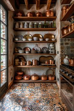 an old kitchen with many pots and pans on the shelves