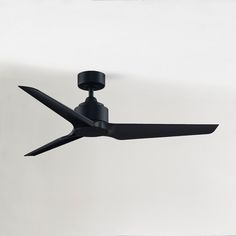 a black ceiling fan in front of a white wall