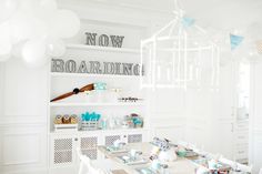 a room filled with lots of white furniture and balloons hanging from the ceiling above it