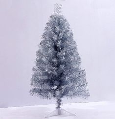 a small white christmas tree in the snow