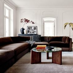 a living room with couches, tables and pictures hanging on the wall above them