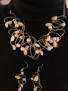 "\"BEACH PARTY\" Wire is twisted into an avant-garde maze, strung with 8 mm pearls and smaller size cowrie shells. Select gold or silver. The necklace measures 18 inches with chains attached to include a lobster claw clasp  for closing and adjusting to a smaller size. If 18 inches is too small, please message me for a longer neckline. Pierce earrings hang to 2 inches, and  are a fine match, made with smaller pearls and smaller cowrie shells. A beautiful expression of summer! Jewelry will arrive Bohemian Pearl Charm Party Jewelry, Handmade Gold Pearl Jewelry Sets, Handmade Gold Jewelry Sets With Pearls, Elegant Beaded Spiral Jewelry, Bohemian Pearl Jewelry For Party, Party Wire Wrapped Pearl Jewelry, Unique Pearl Drop Jewelry For Party, Adjustable Metal Pearl Necklace For Party, Adjustable Pearl Necklace For Parties, Costume Jewelry Style