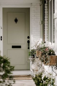 a white front door with two vases filled with flowers