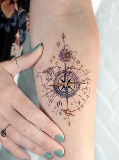 a woman's arm with a compass tattoo on the left side of her body