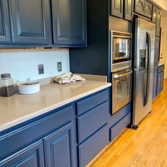 a kitchen with blue cabinets and stainless steel appliances