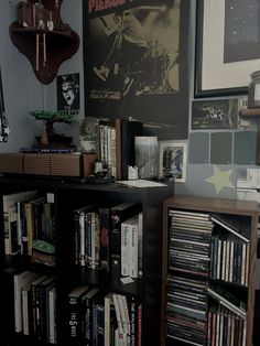 a bookshelf filled with lots of books next to a wall mounted movie poster