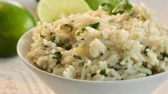 a white bowl filled with rice next to limes