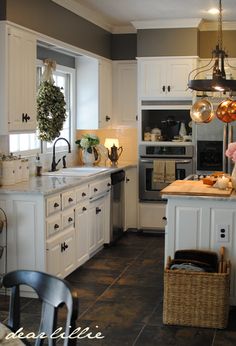 a kitchen filled with lots of white cabinets