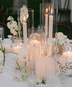 a table topped with lots of white flowers and candles