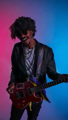 a man with an afro holding a red guitar in front of a blue and pink background