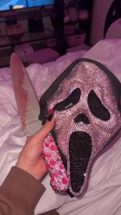 a person holding a knife in front of a pink mask