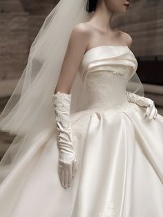 a woman in a white wedding dress and gloves