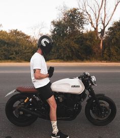 a man sitting on top of a white motorcycle