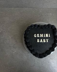 a cake with the words gemini baby written on it is sitting on a table