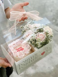 a person holding a box with flowers in it