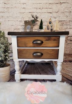 a white and brown dresser sitting on top of a wooden floor next to a brick wall