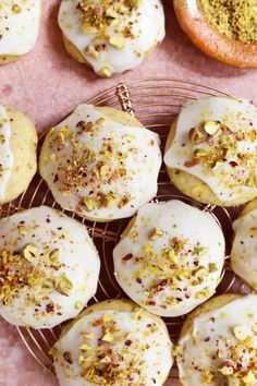 a basket filled with white frosted donuts covered in sprinkles and pistachio