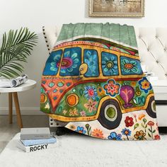 a colorful bus with flowers on it is sitting in front of a white couch