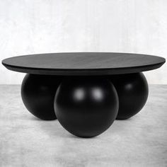 three black balls sitting on top of a table