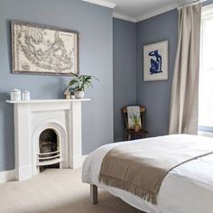 a bedroom with blue walls and a white fireplace